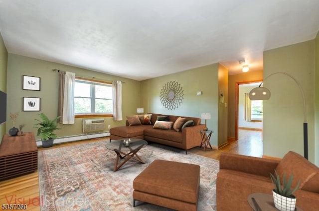 living area featuring a baseboard radiator, wood finished floors, a wall mounted AC, and baseboards