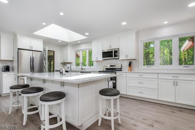 8 Reger Rd, Chester Twp, NJ 07836 - kitchen with stainless steel appliances, decorative backsplash, a sink, light countertops, and white cabinetry