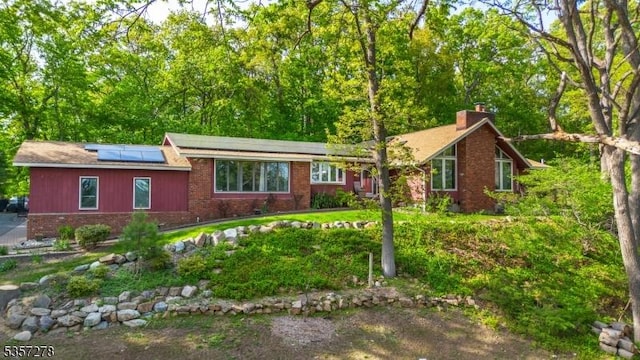 8 Reger Rd, Chester Twp, NJ 07836 - ranch-style house with brick siding, roof mounted solar panels, and a chimney