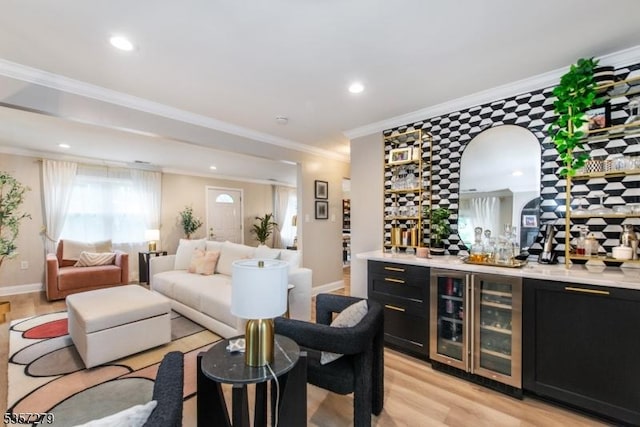 living room featuring wine cooler, bar, light wood-style flooring, recessed lighting, and ornamental molding
