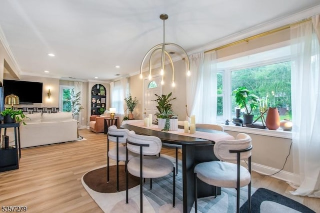 dining area featuring ornamental molding, light wood-style floors, recessed lighting, and baseboards