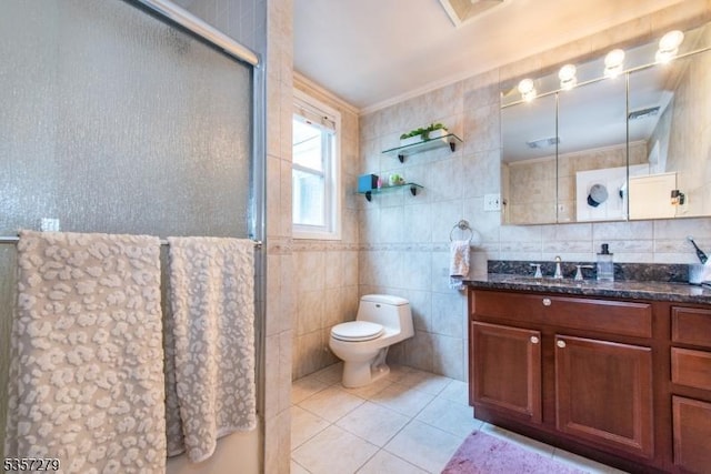 full bath with a shower with shower door, tile walls, vanity, toilet, and tile patterned floors