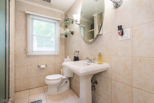 bathroom featuring ornamental molding, toilet, tile patterned flooring, and tile walls