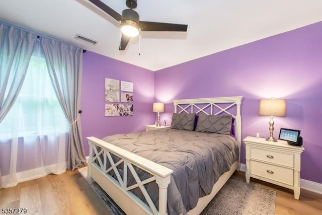 bedroom featuring wood finished floors, a ceiling fan, and baseboards