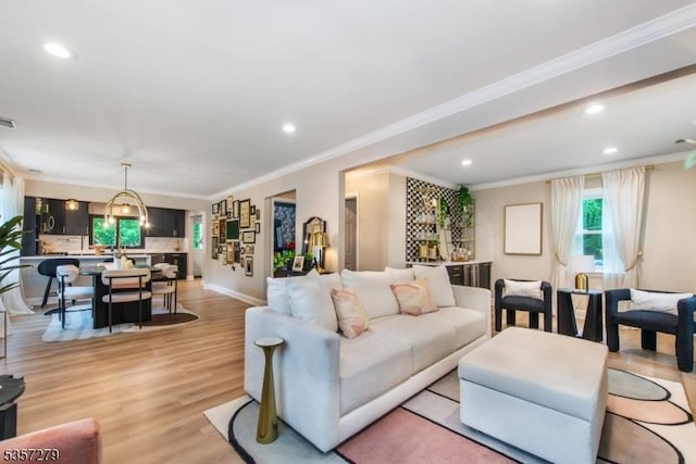 living room featuring recessed lighting, crown molding, light wood finished floors, and baseboards