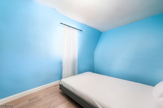 bedroom with wood finished floors and baseboards