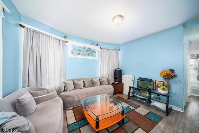 living area with plenty of natural light, wood finished floors, and baseboards