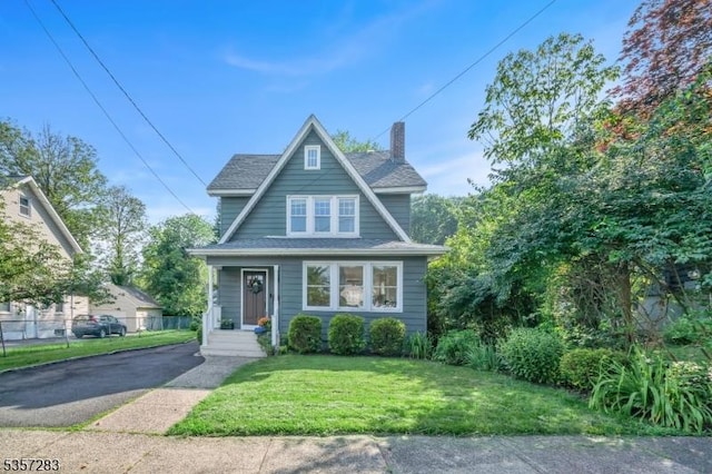 188 Watchung Ter, Scotch Plains Twp, NJ 07076 - view of front of property with a chimney, a front yard, asphalt driveway, and roof with shingles