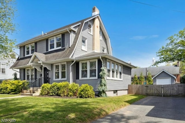 dutch colonial with a chimney, a gambrel roof, and a gate