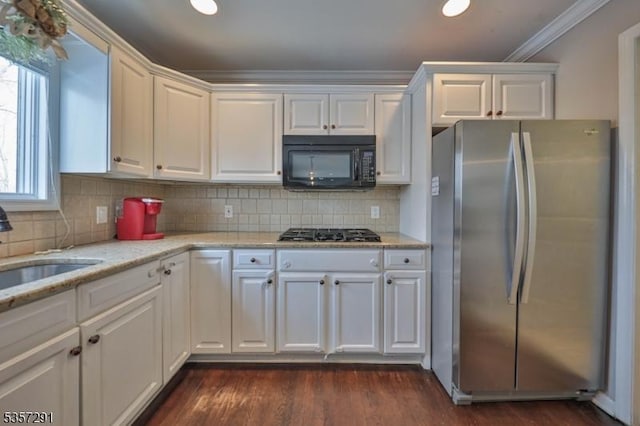 kitchen featuring freestanding refrigerator, black microwave, gas cooktop, white cabinetry, and dark wood-style floors