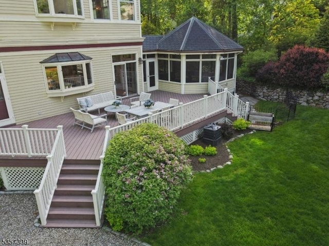 deck featuring a sunroom, stairs, a lawn, and an outdoor hangout area