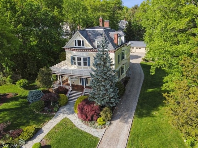 view of front of house with a chimney, a front yard, stairway, and a porch