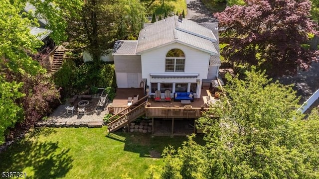 back of house with stairway, an outdoor living space with a fire pit, a deck, a yard, and roof with shingles