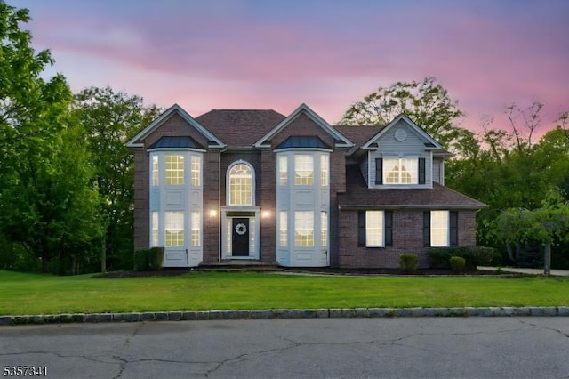 view of front facade featuring a yard and brick siding