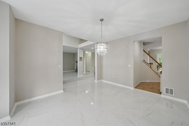 unfurnished room with marble tiled flooring, a chandelier, baseboards, and stairs