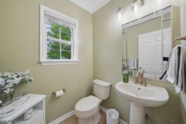 bathroom featuring toilet, baseboards, a sink, and ornamental molding