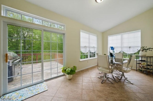 dining space with lofted ceiling, baseboards, and tile patterned flooring