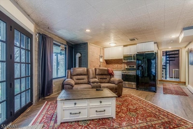 living area featuring light wood-type flooring, a wood stove, and radiator