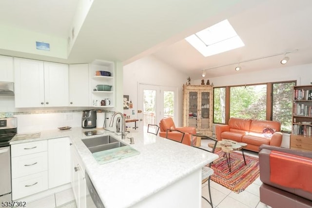 23 Horizon Dr, Roxbury Twp, NJ 07876 - kitchen featuring a sink, a skylight, a peninsula, light tile patterned flooring, and light countertops