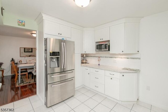 23 Horizon Dr, Roxbury Twp, NJ 07876 - kitchen with appliances with stainless steel finishes, white cabinets, backsplash, light tile patterned floors, and baseboards