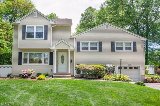 split level home with a garage and asphalt driveway