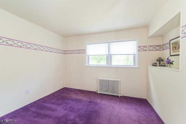 carpeted empty room with radiator heating unit
