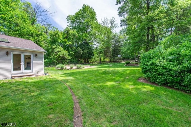 view of green lawn featuring french doors
