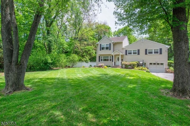 tri-level home featuring an attached garage, concrete driveway, and a front lawn