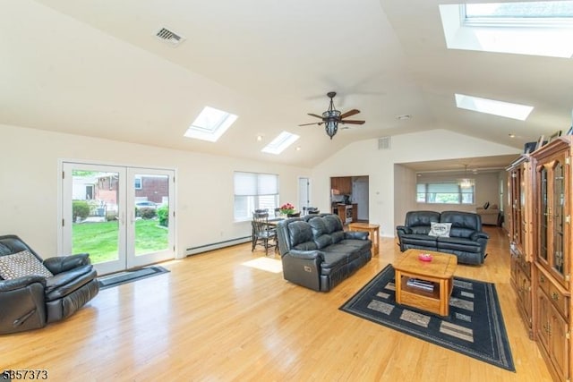 living room with a skylight, baseboard heating, lofted ceiling, light wood-style floors, and ceiling fan