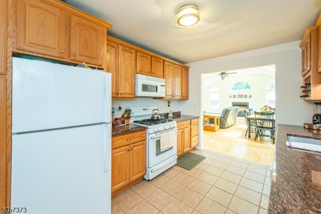 kitchen featuring white appliances, light tile patterned floors, ceiling fan, crown molding, and a fireplace