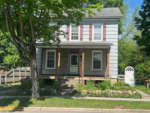 view of front of house featuring a porch and fence