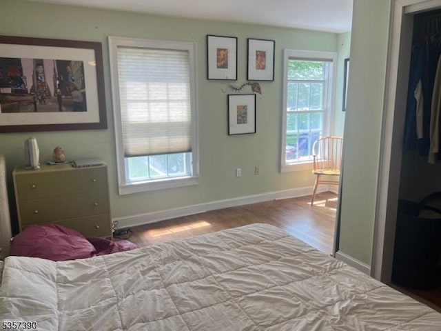 bedroom featuring wood finished floors and baseboards