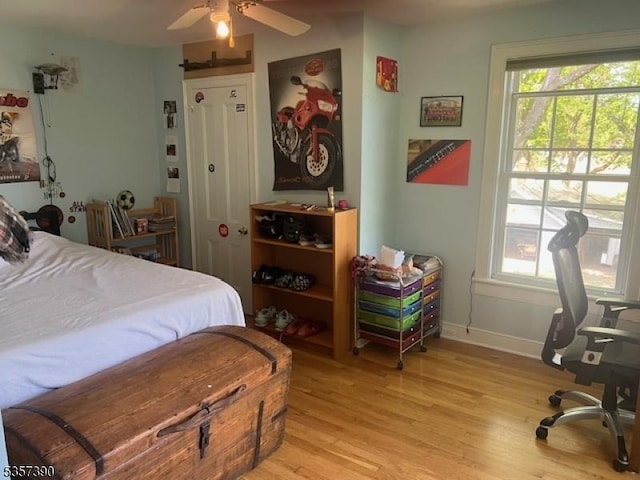 bedroom featuring light wood finished floors, multiple windows, and baseboards