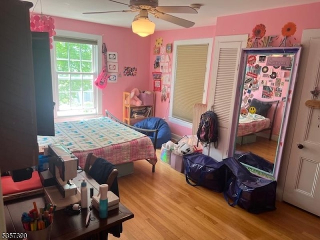 bedroom with wood finished floors, a ceiling fan, and a closet