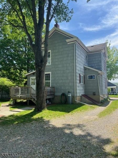 view of side of property featuring a wooden deck and a chimney