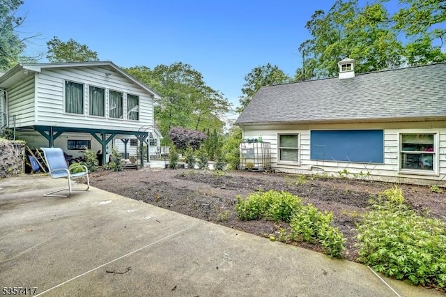 2 Troll Ln, Rockaway Twp, NJ 07866 - view of side of home with a patio area, a shingled roof, and a chimney