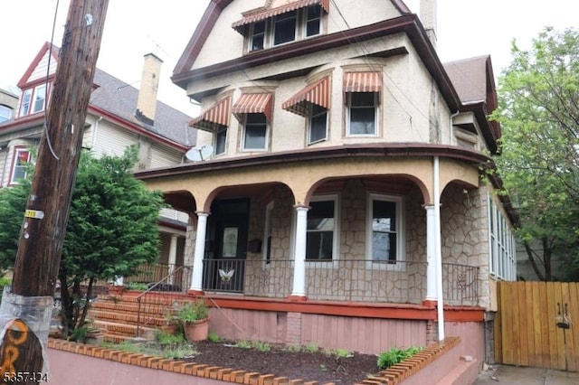 94 Lembeck Ave, Jersey City, NJ 07305 - view of front of home with covered porch, stone siding, and stucco siding