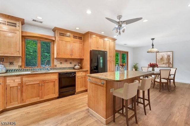 10 Hunts Mill Rd, Clinton Town, NJ 08809 - kitchen with black appliances, decorative backsplash, a breakfast bar, a center island, and light wood finished floors