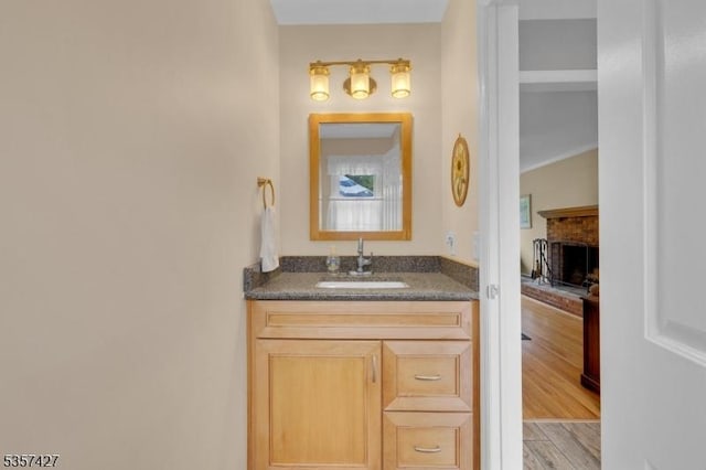19 Bennington Dr, Mount Olive Twp, NJ 07836 - bathroom featuring a brick fireplace, vanity, and wood finished floors