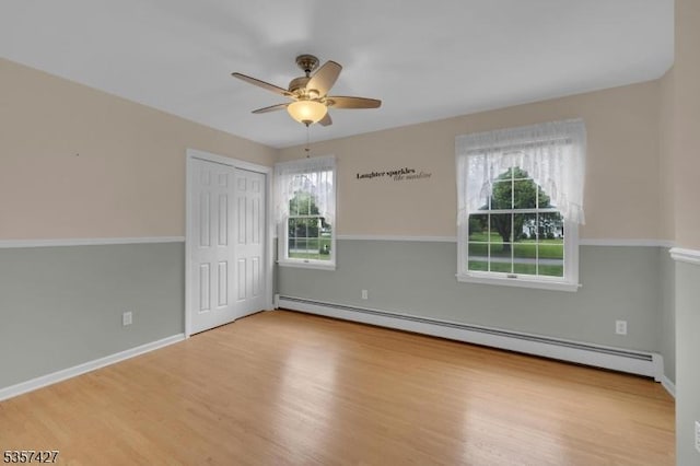 19 Bennington Dr, Mount Olive Twp, NJ 07836 - unfurnished bedroom featuring a baseboard radiator, wood finished floors, a closet, baseboards, and a ceiling fan