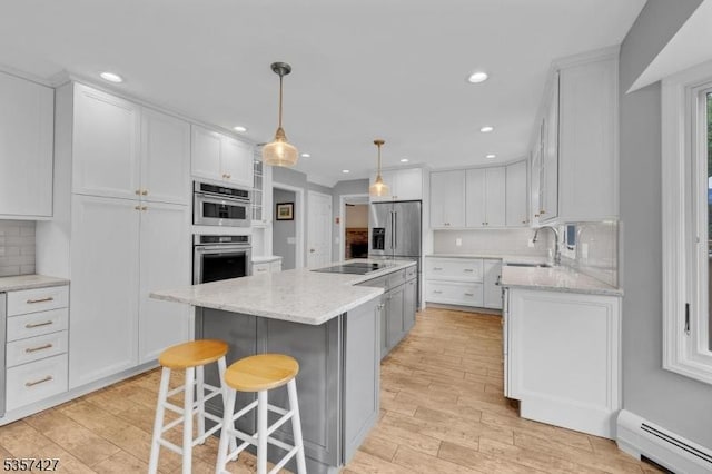 19 Bennington Dr, Mount Olive Twp, NJ 07836 - kitchen with a baseboard heating unit, a sink, light wood-type flooring, appliances with stainless steel finishes, and recessed lighting
