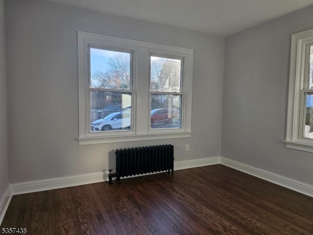 31 Wyckoff Ave, Wyckoff Twp, NJ 07446 - empty room with radiator heating unit, healthy amount of natural light, dark wood-style floors, and baseboards