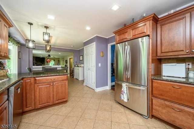 49 Sliker Rd, Lebanon Twp, NJ 08826 - kitchen featuring stainless steel appliances, brown cabinetry, light tile patterned floors, a peninsula, and dark stone countertops