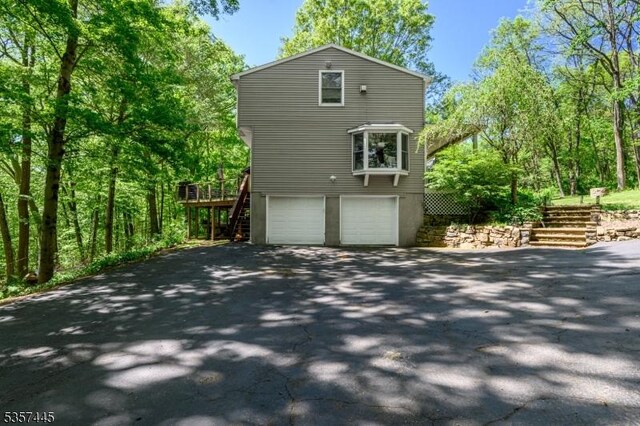 49 Sliker Rd, Lebanon Twp, NJ 08826 - view of side of home featuring stairs, asphalt driveway, and a garage