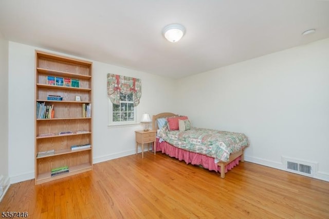 bedroom with light wood-type flooring and baseboards