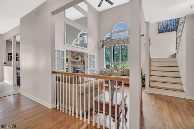 7 Rine Rd, Hillsborough Twp, NJ 08844 - stairs featuring ceiling fan, wood finished floors, baseboards, a towering ceiling, and a fireplace