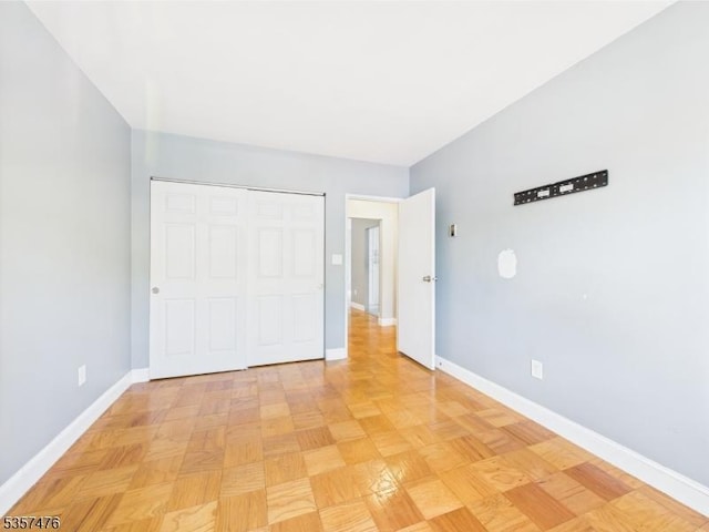 unfurnished bedroom with baseboards and a closet