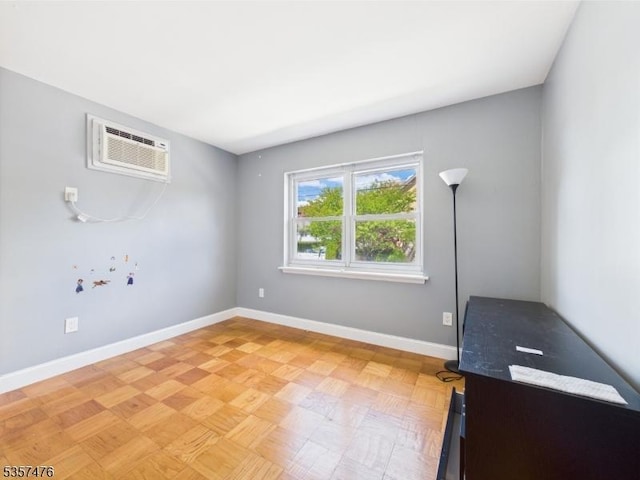 spare room with baseboards and a wall mounted air conditioner