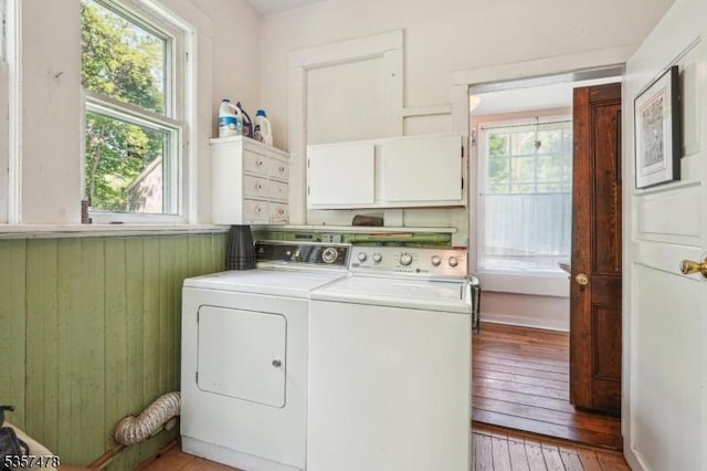 19 E Mill Rd, Washington Twp, NJ 07853 - laundry room featuring washer and dryer, cabinet space, light wood-style flooring, and wood walls