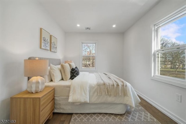 bedroom with dark wood finished floors, baseboards, and recessed lighting